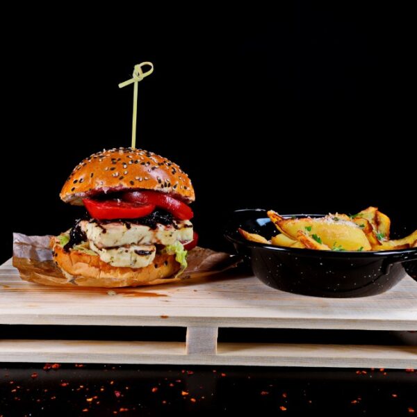 Burger halloumi cu sos calipso, si iceberg, rosii si castrevete, insotit de cartofi prajiti cu usturoi si parmezan