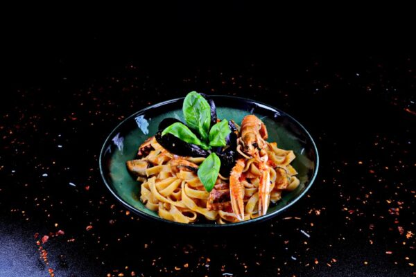Tagliatelle cu fructe de mare stinse cu prossecco alb si garnisite cu rosii cherry si busuioc verde